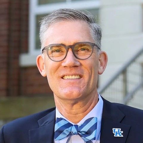 Nicholas J. Pace smiling, with short gray hair, glasses and a blue striped bow tie